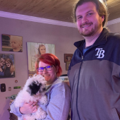 Couple holding their puppy and smiling