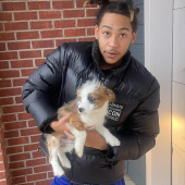 Young man hugging Austrlaian Shepherd puppy