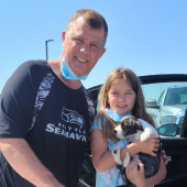 Father and daughter holding their puppy after delivery