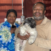 Husband and wife holding their newly delivered puppy