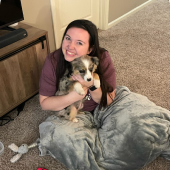 Mawoo customer hugging her puppy and smiling on her house floor