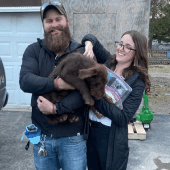 Mawoo male and female customer holding a brown Labrador Retriever puppy