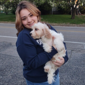 Mawoo young customer smiling while hugging new white puppy